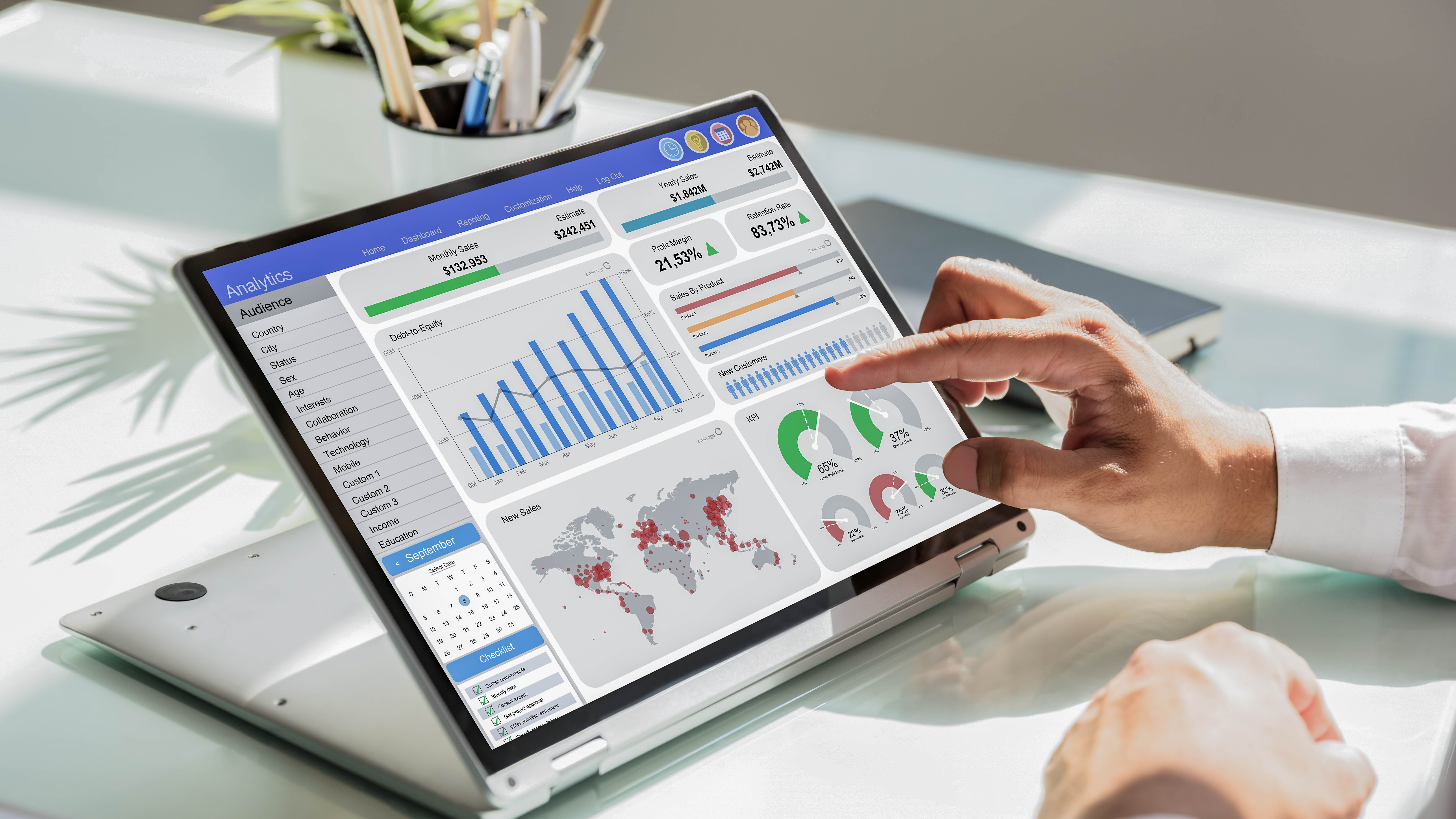 Ein Laptop zeigt ein Analyse-Dashboard mit Diagrammen, Statistiken und einer Weltkarte, während eine Hand darauf tippt.