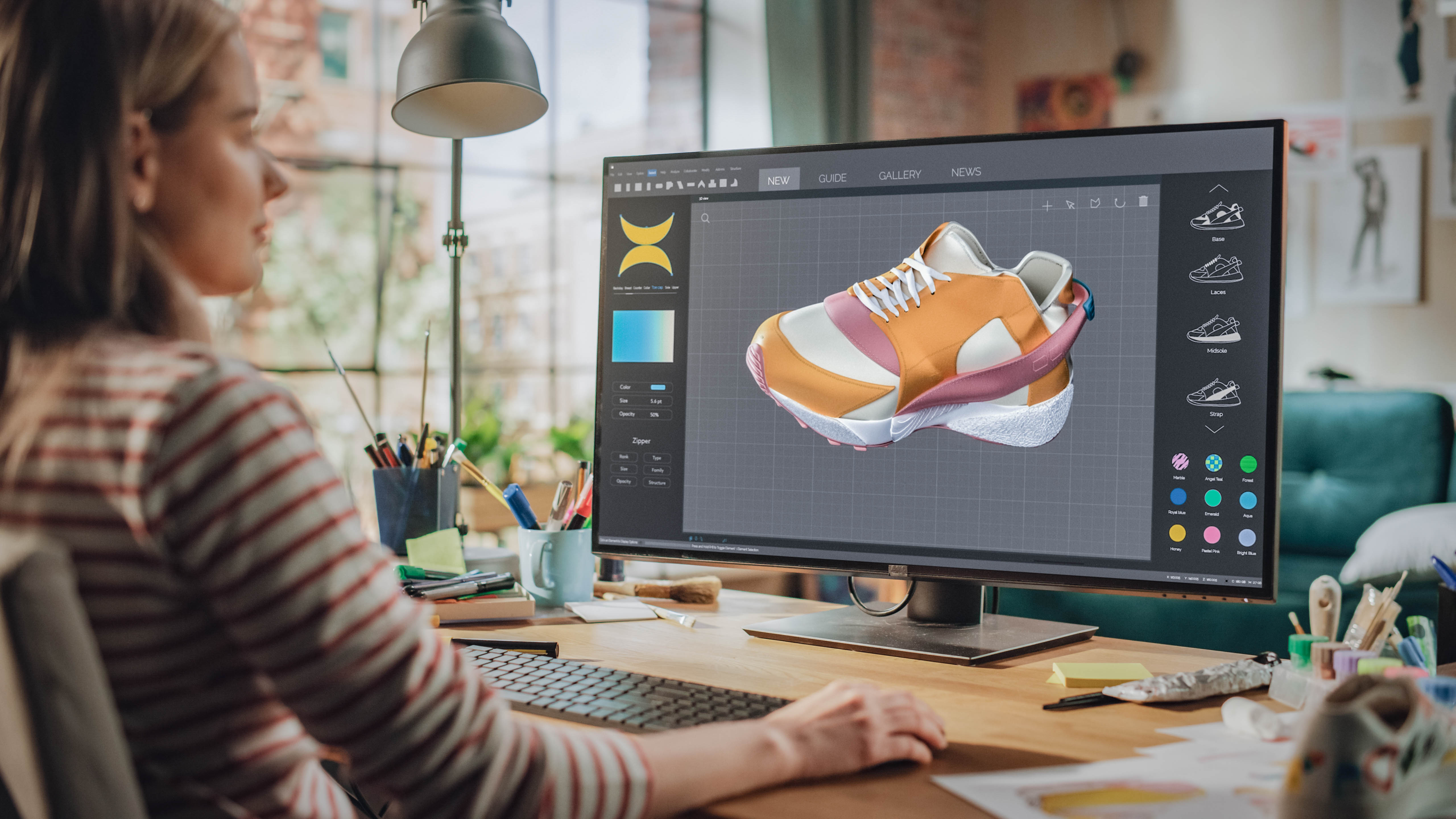 Eine Person arbeitet an einem Computer, um ein 3D-Modell eines Schuhs zu gestalten.