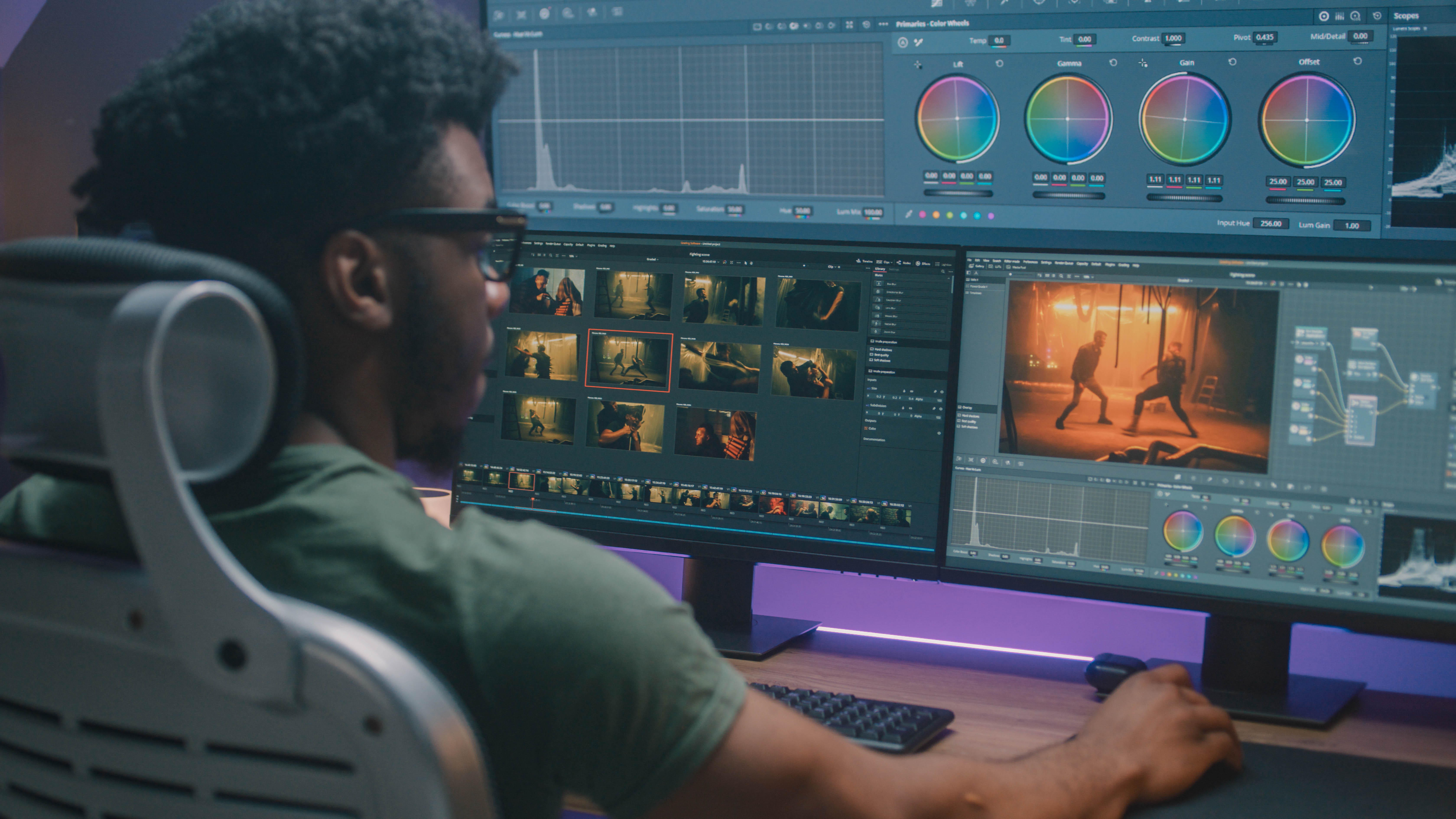 Ein Mann sitzt an einem Schreibtisch und bearbeitet Videos auf zwei großen Monitoren mit verschiedenen Software-Tools.