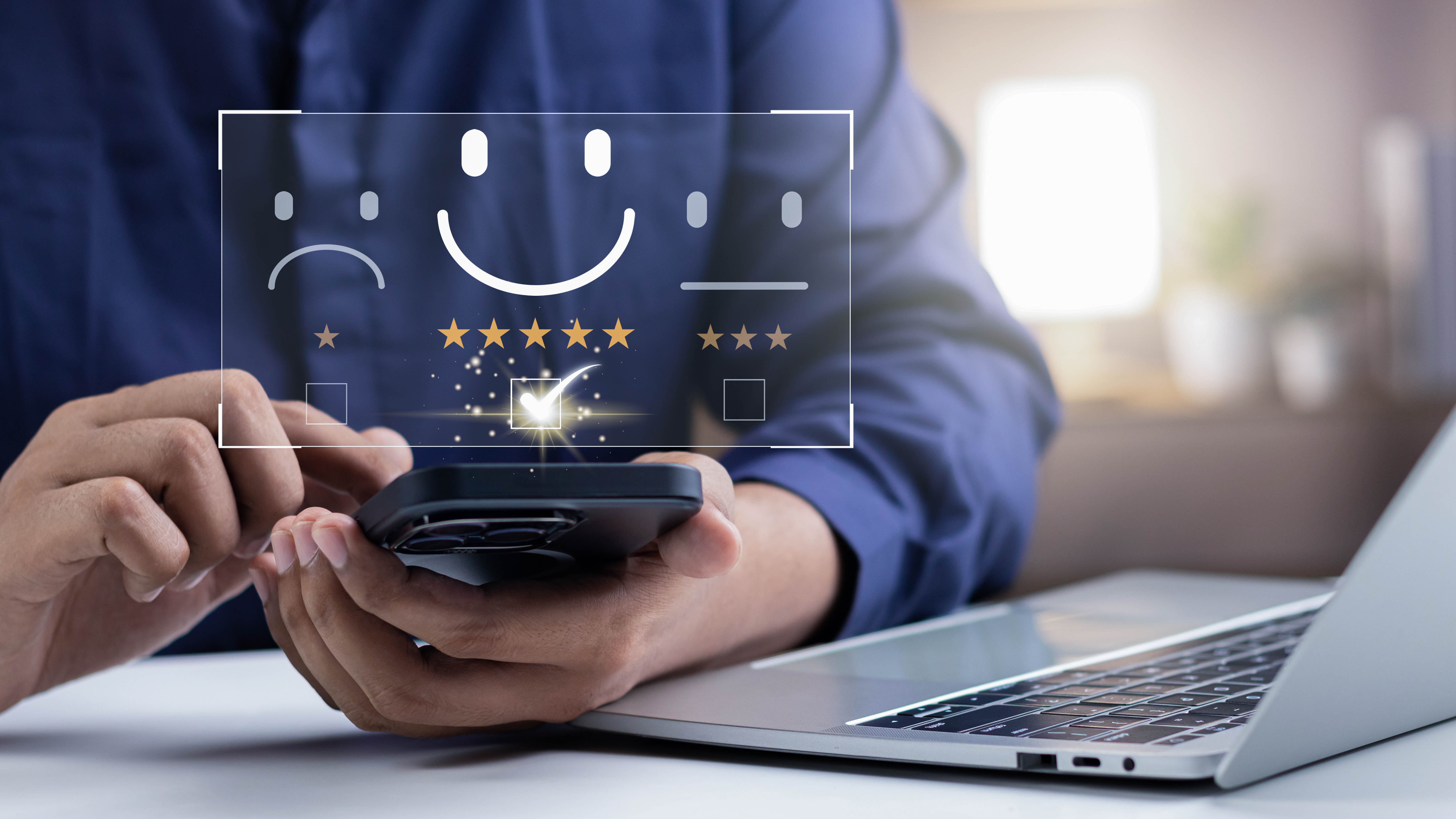 Hände halten ein Smartphone, während auf dem Bildschirm Smileys und Sterne zur Bewertung angezeigt werden.