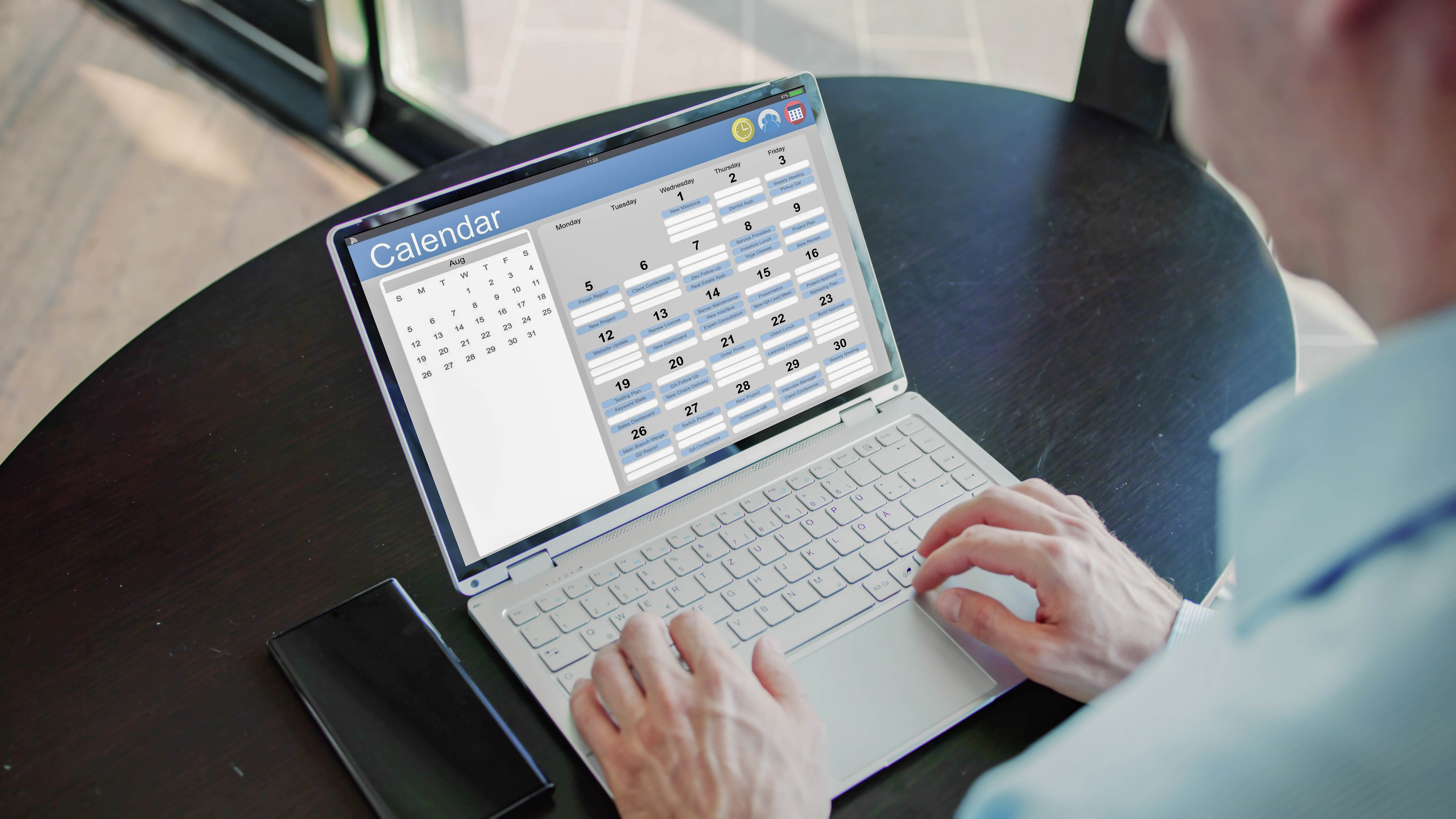Eine Person tippt auf der Tastatur eines Laptops, der einen Kalender auf dem Bildschirm zeigt.