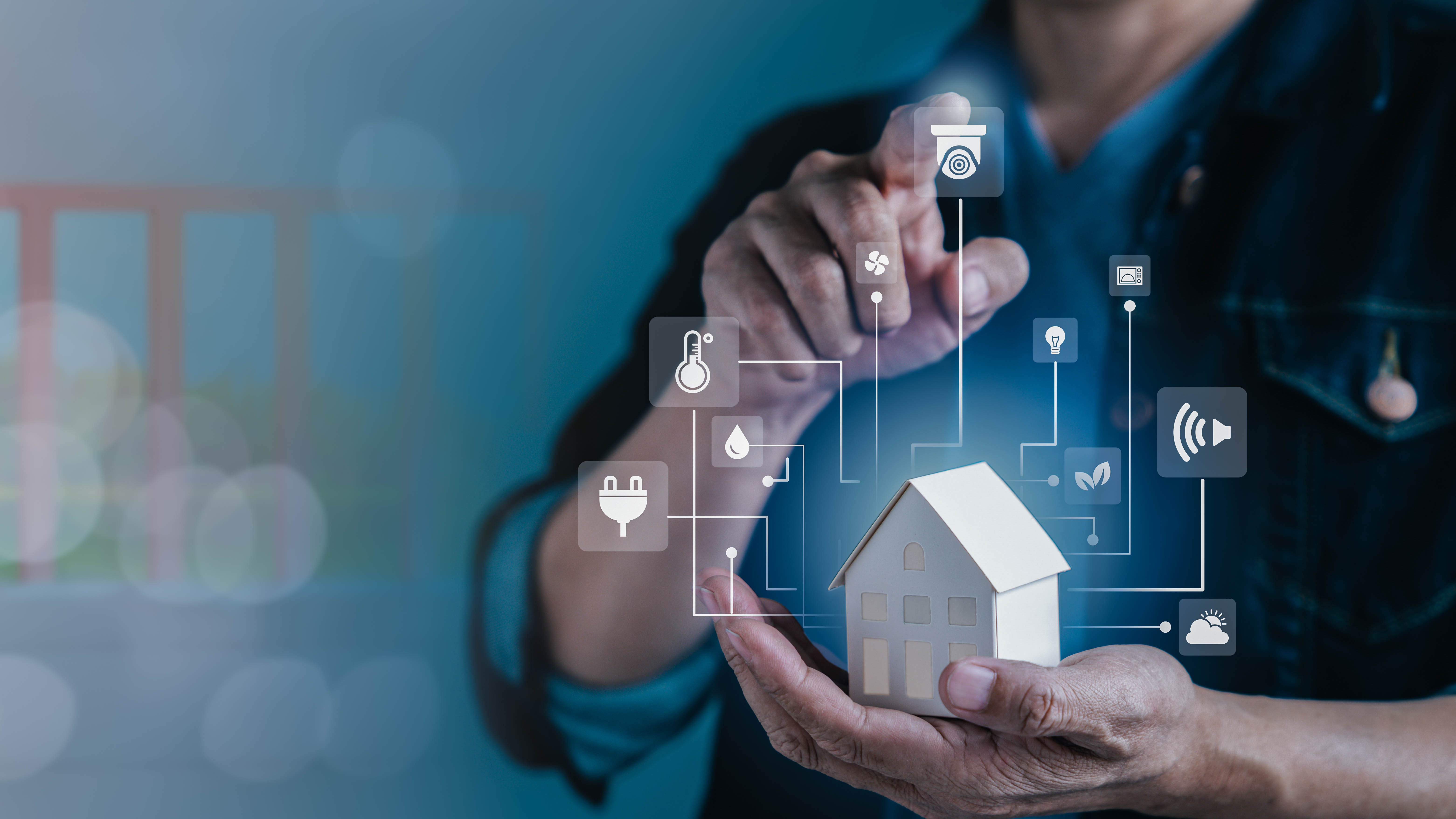 Eine Person hält ein kleines Modellhaus und zeigt auf digitale Symbole für Smart-Home-Funktionen.