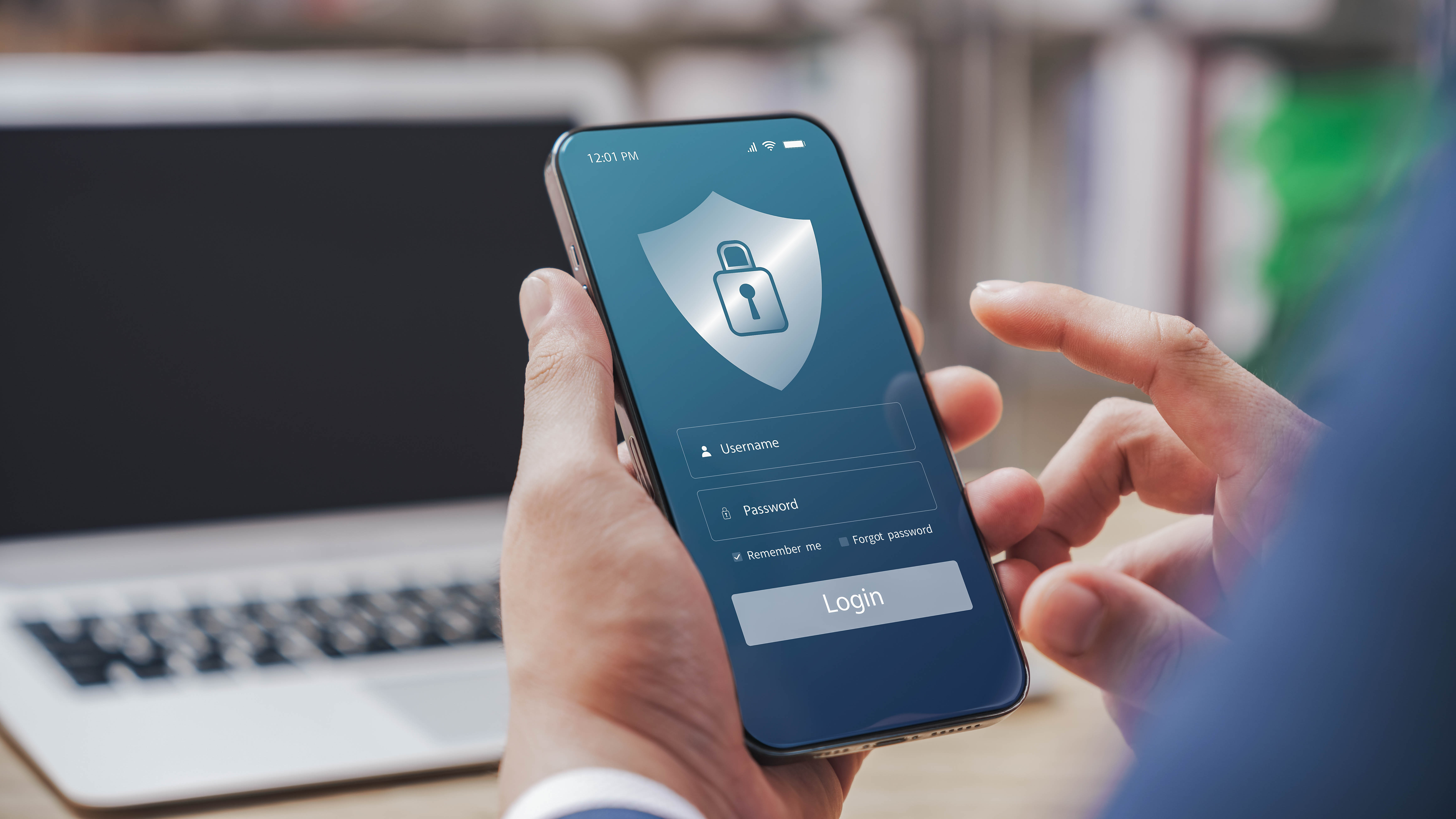Ein Benutzer hält ein Smartphone mit einem Login-Bildschirm, der ein Sicherheitssymbol zeigt.