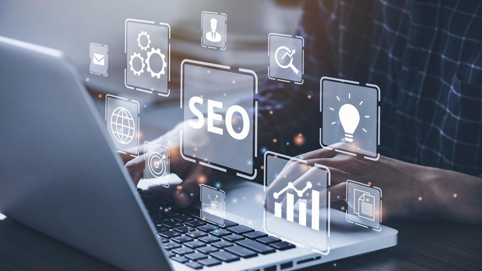 Hände tippen auf einer Laptop-Tastatur, umgeben von grafischen SEO-Symbolen und Datenvisualisierungen.