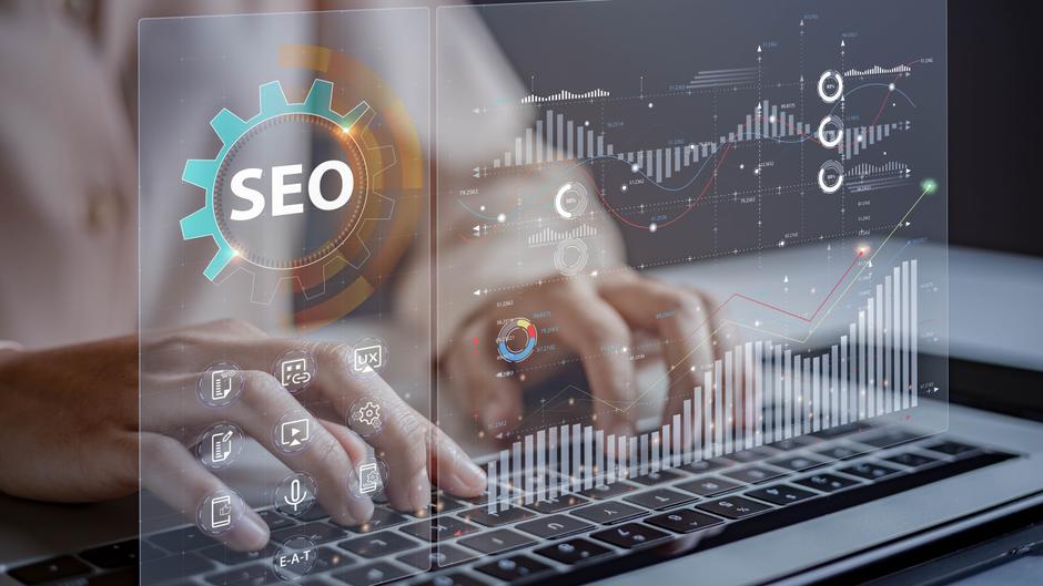 Hände tippen auf einer Laptop-Tastatur, während digitale SEO-Daten und Grafiken angezeigt werden.