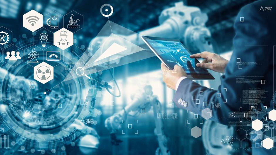 Hand eines Mannes, der ein Tablet hält, mit digitalen Icons und Grafiken im Hintergrund, die industrielle Automatisierung darstellen.