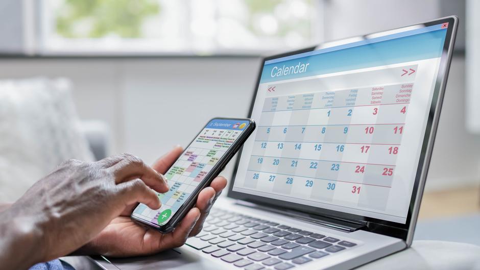 Ein Smartphone und ein Laptop zeigen jeweils einen Kalender mit Terminen und Daten.