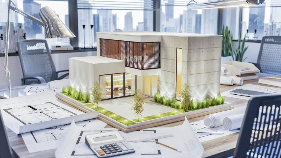 Modell eines modernen Gebäudes mit Pflanzen und Licht, umgeben von Architekturplänen und Büromaterialien.