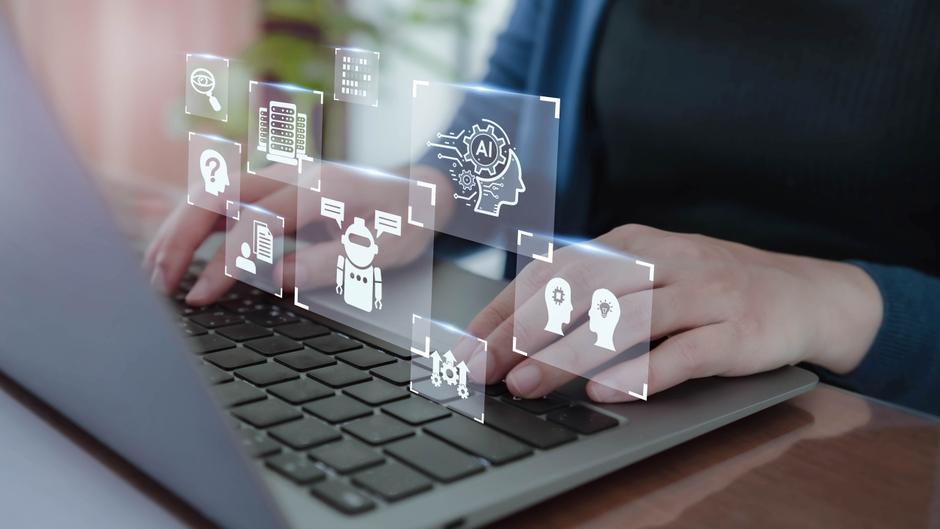 Hände tippen auf einer Laptop-Tastatur, umgeben von grafischen Symbolen zu KI und Datenanalyse.