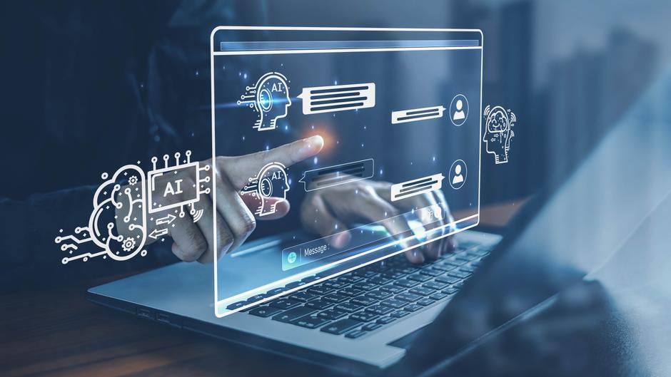 Hand, die auf ein holographisches Interface mit AI-Symbolen und Chat-Nachrichten zeigt, vor einem Laptop.