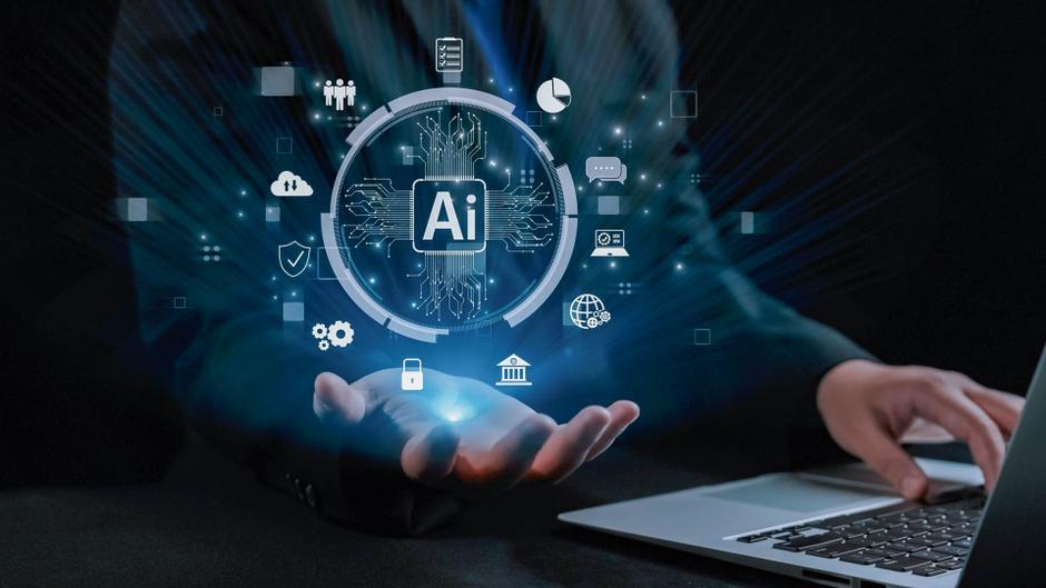 Eine Hand hält ein leuchtendes Symbol für Künstliche Intelligenz (AI) umgeben von verschiedenen digitalen Icons.