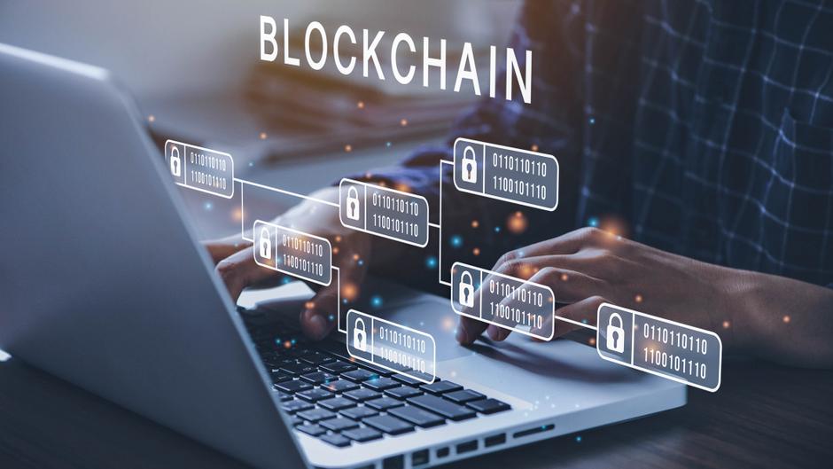 Hände tippen auf einer Laptop-Tastatur, während digitale Blockchain-Symbole und Daten angezeigt werden.